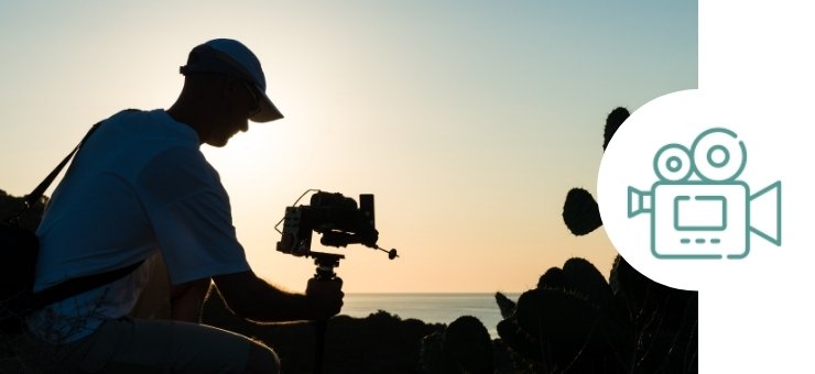 trabajador audiovisual grabando en la playa el atardecer